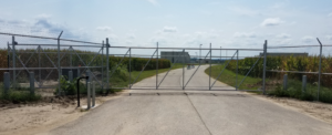 Airport secured by a chain link cantilever gate with key pad entry and barb wire